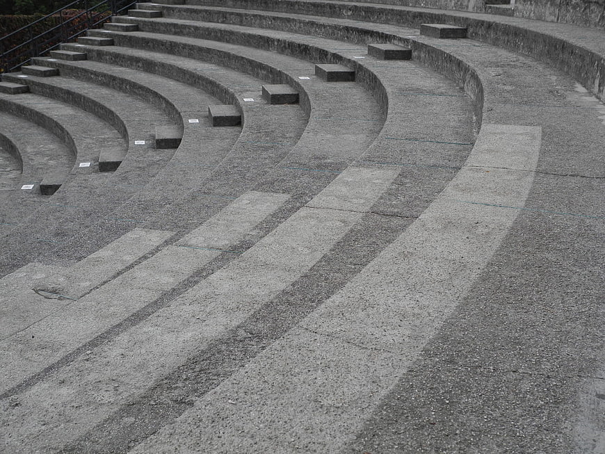 Curved concrete amphitheater seating with stone steps