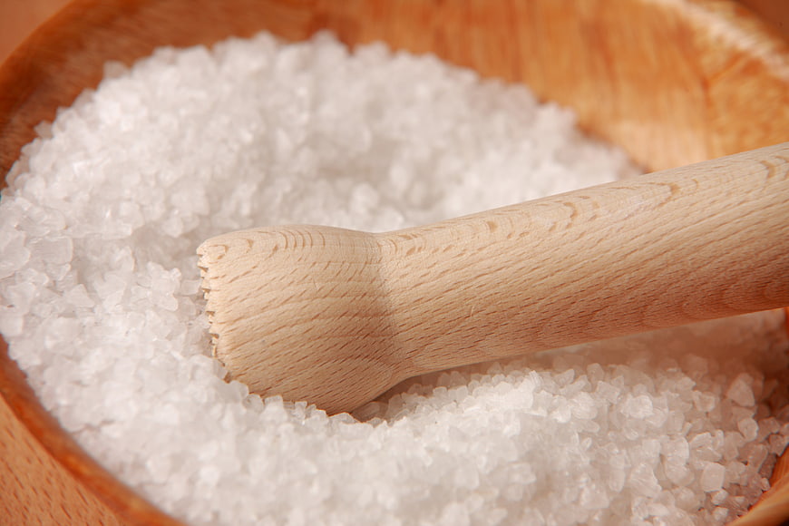 Coarse sea salt in wooden mortar with pestle
