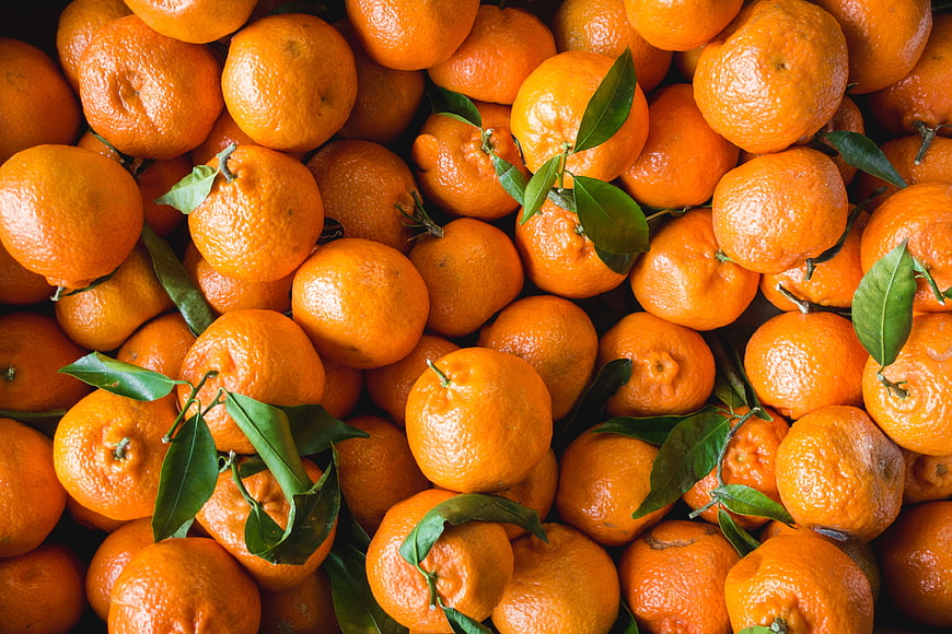Fresh Oranges with Green Leaves Background