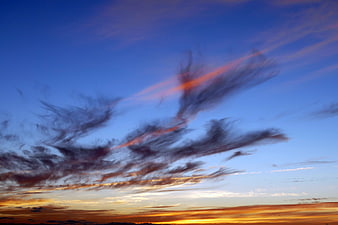 Dramatic Sunset Sky with Streaked Clouds and Golden Horizon