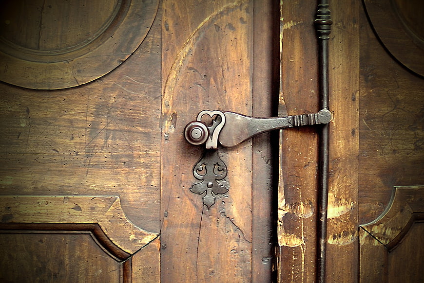 Close-up of vintage metal latch on weathered wooden door