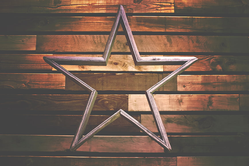 Rustic wooden star decoration on plank background