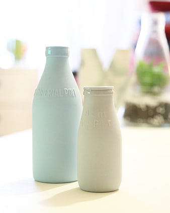 Minimalist pastel milk bottles on white table