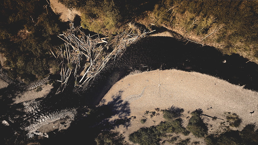 Aerial drone view of river bend with fallen trees and sandbar