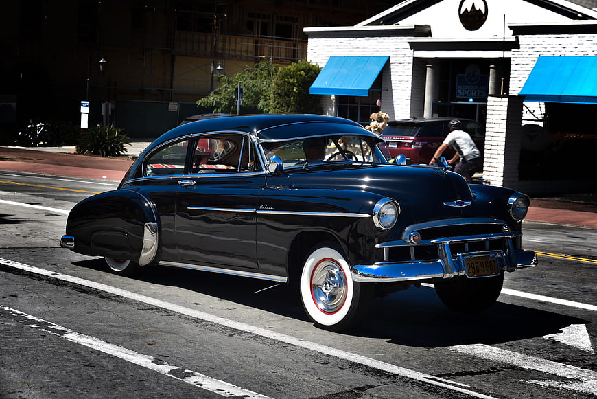 Classic Black 1950s Chevrolet Bel Air Driving on Street