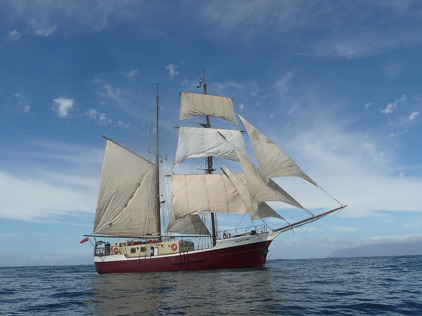 Vintage Brigantine Sailing on Blue Ocean Under Clear Sky