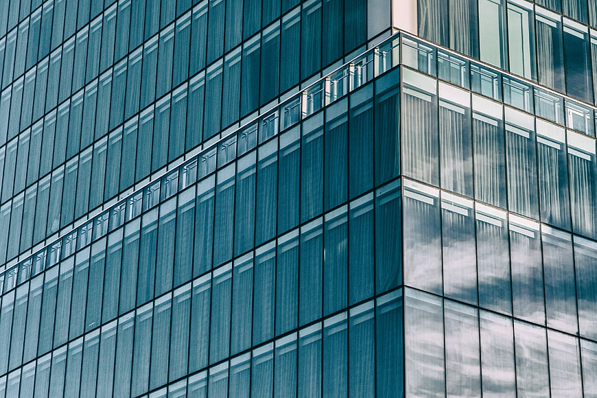 Modern Glass Office Building Facade with Cloud Reflections