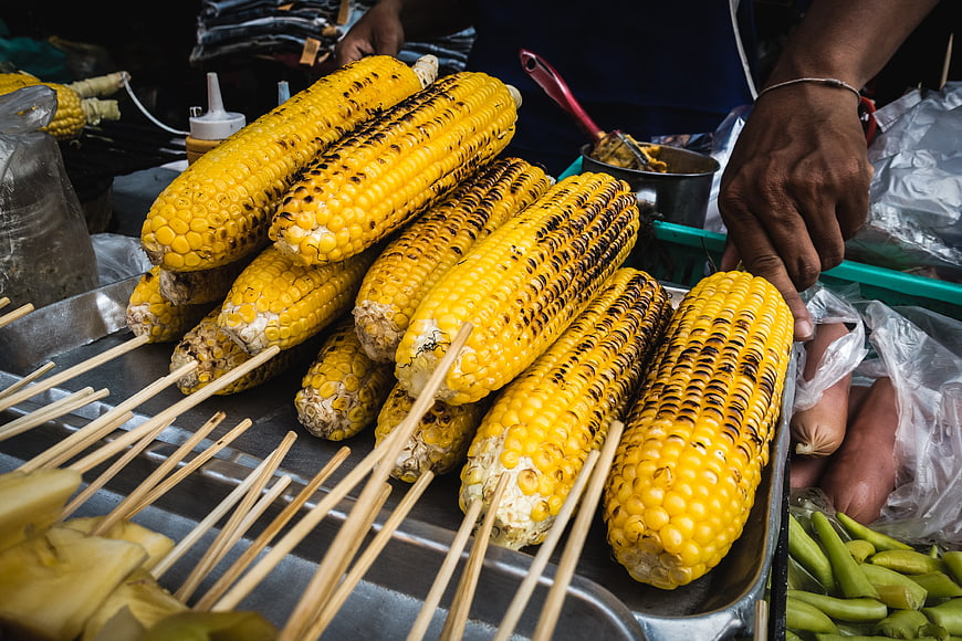 Grilled corn on the cob street food display