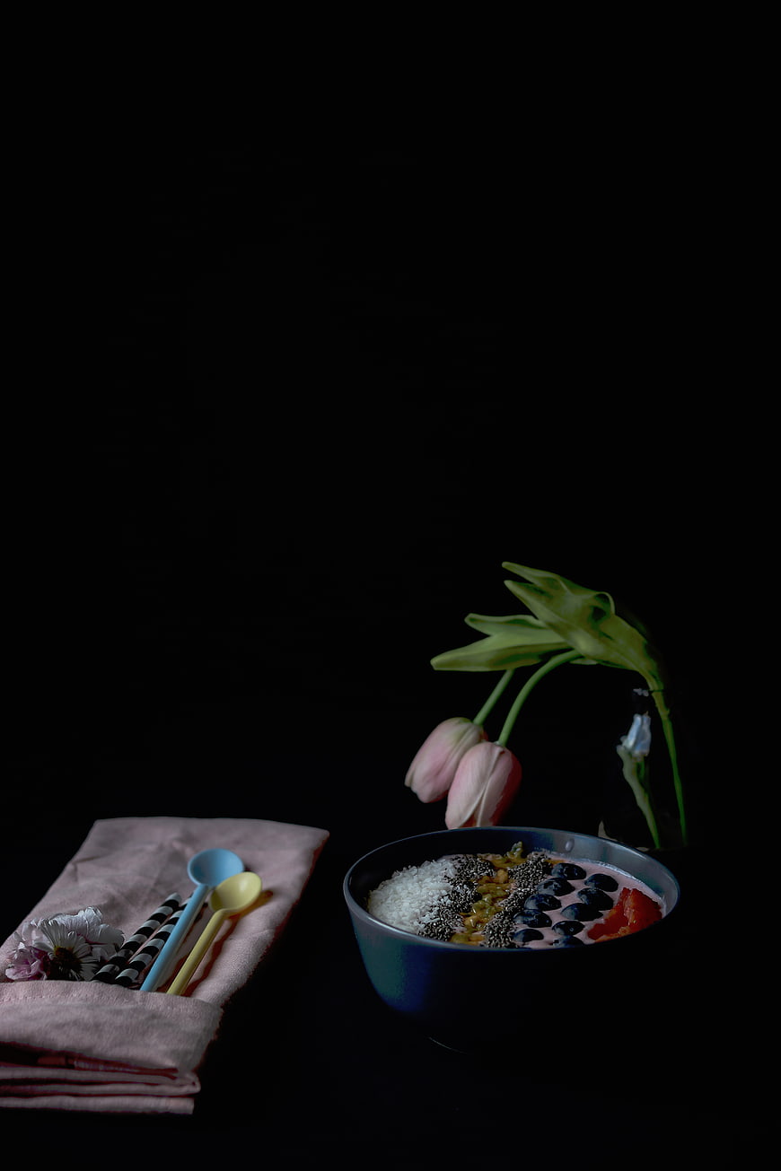 Dark moody smoothie bowl with blueberries and flowers