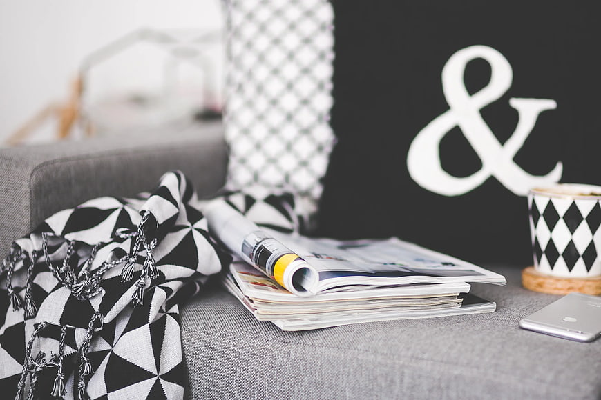 Black and white geometric decor on gray sofa with magazines