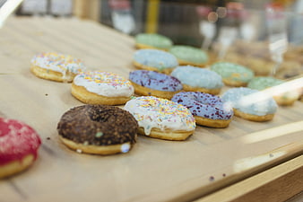 Assorted Glazed Donuts With Sprinkles On Wooden Display Tray