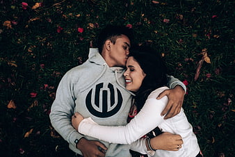 Happy couple hugging and kissing while lying on grass