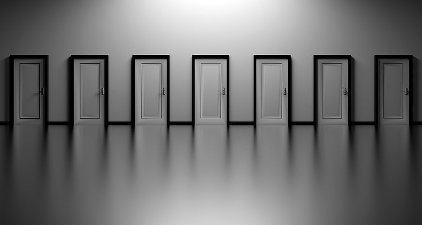 Row of white doors in a minimalist gray hallway