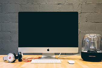 Modern Workspace with iMac, Headphones, and Speaker on Wooden Desk