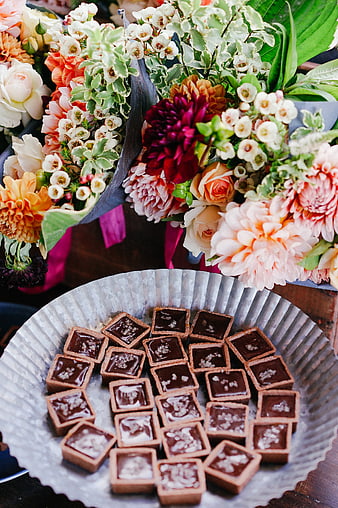Square chocolate truffles on metal platter with colorful flowers