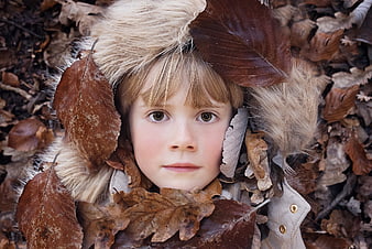 Close-up portrait of a young girl in autumn leaves