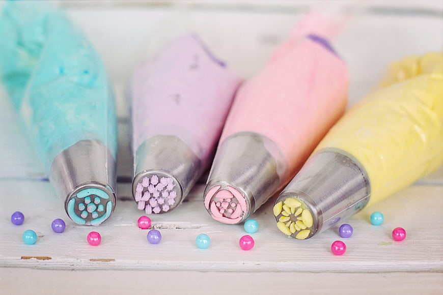 Colorful piping bags with frosting tips and sprinkles