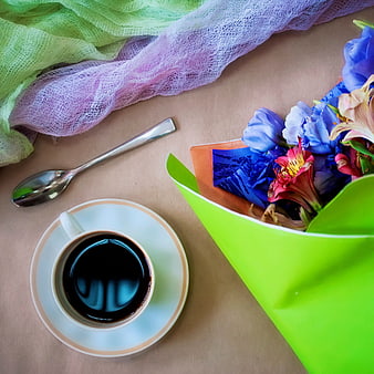 Flat lay of coffee cup and colorful spring flower bouquet