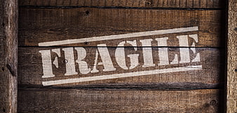 Fragile stamp on rustic wooden crate background