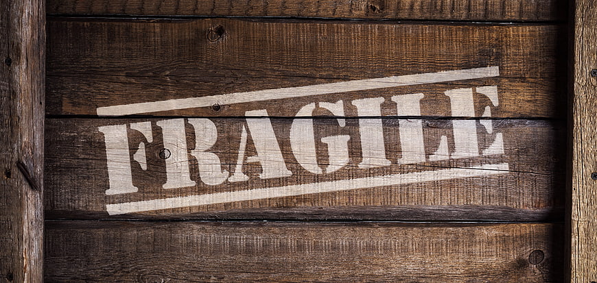 Fragile stamp on rustic wooden crate background