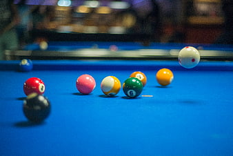 Colorful billiard balls on blue pool table with action