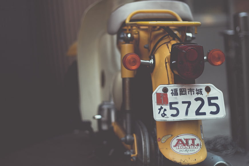 Rear View of Vintage Yellow Honda Scooter with License Plate