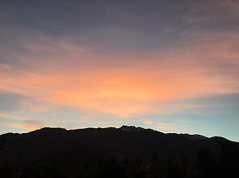 Silhouette of mountains against a vibrant sunset sky