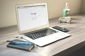 MacBook Laptop on Wooden Desk with Smartphone and Notebook