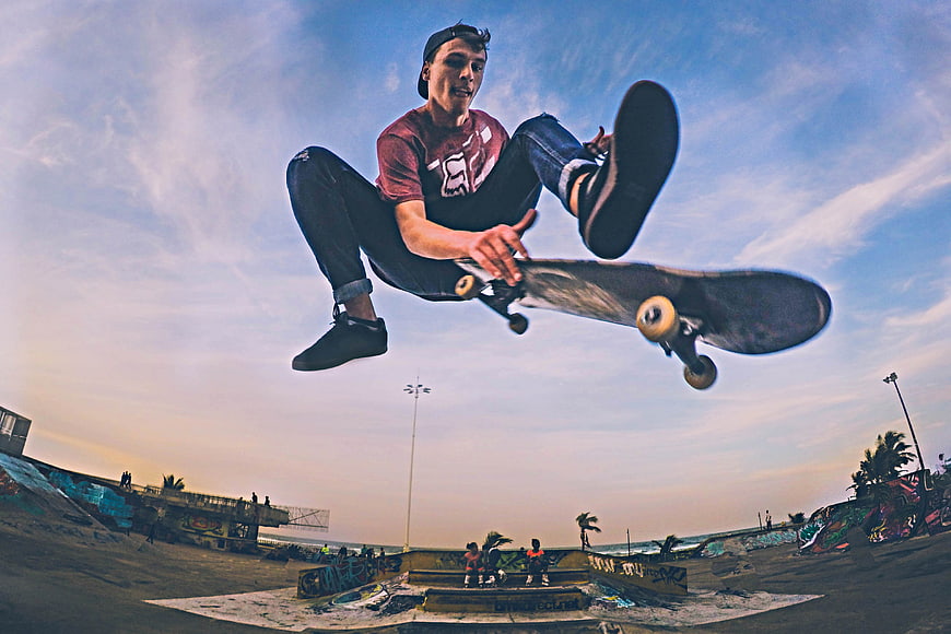 Skateboarder performing high jump trick at skatepark