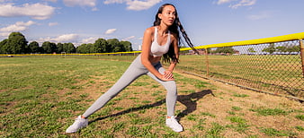 Athletic Woman Stretching on Outdoor Sports Field