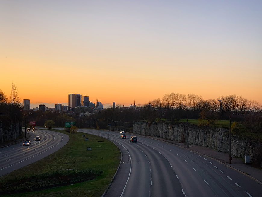 Highway Curving Towards City Skyline at Sunset