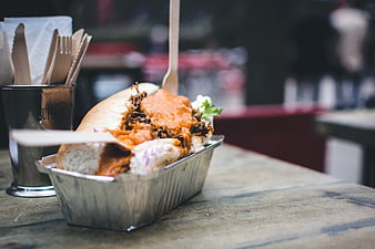Pulled pork sandwich with buffalo sauce in foil tray