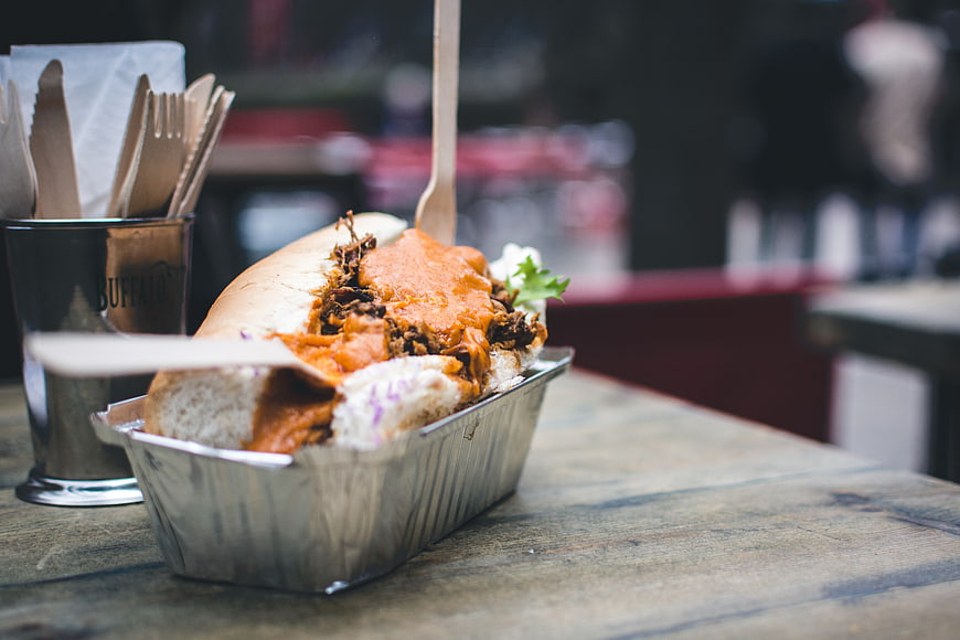 Pulled pork sandwich with buffalo sauce in foil tray
