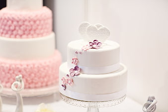 Elegant white wedding cake with pink floral decorations