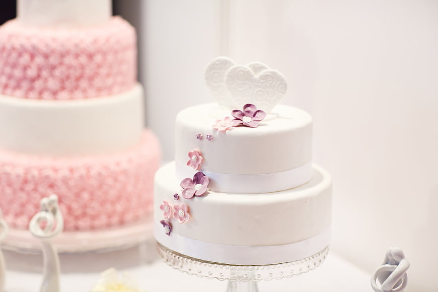 Elegant white wedding cake with pink floral decorations