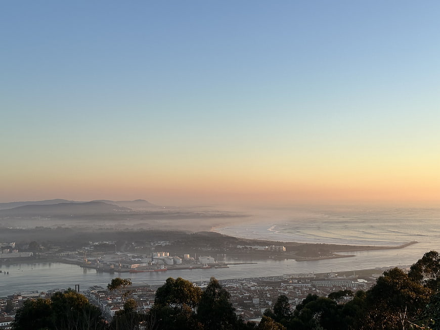 Misty coastal cityscape at sunrise with harbor and ocean view