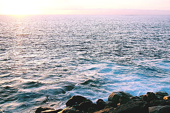 Sunset Ocean Waves Crashing on Rocky Shoreline