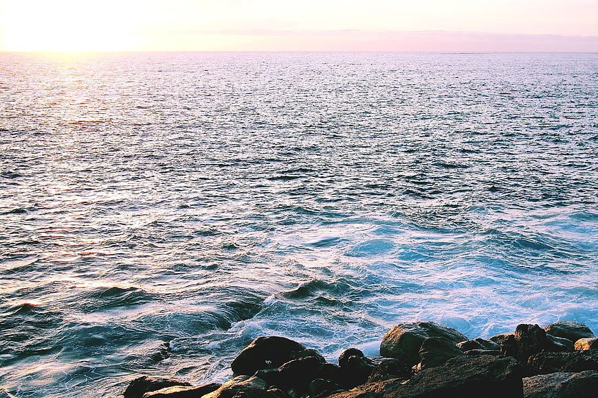 Sunset Ocean Waves Crashing on Rocky Shoreline