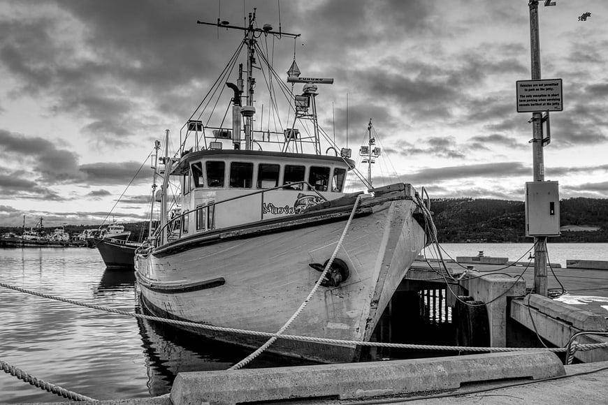 Black and white fishing boat docked at harbor