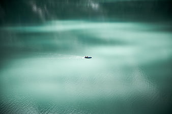 Aerial view of small boat on turquoise lake
