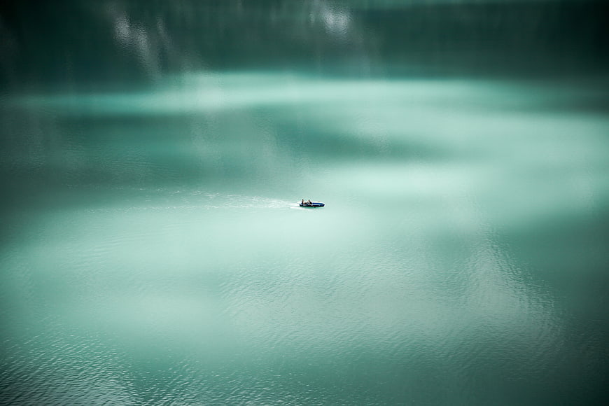 Aerial view of small boat on turquoise lake