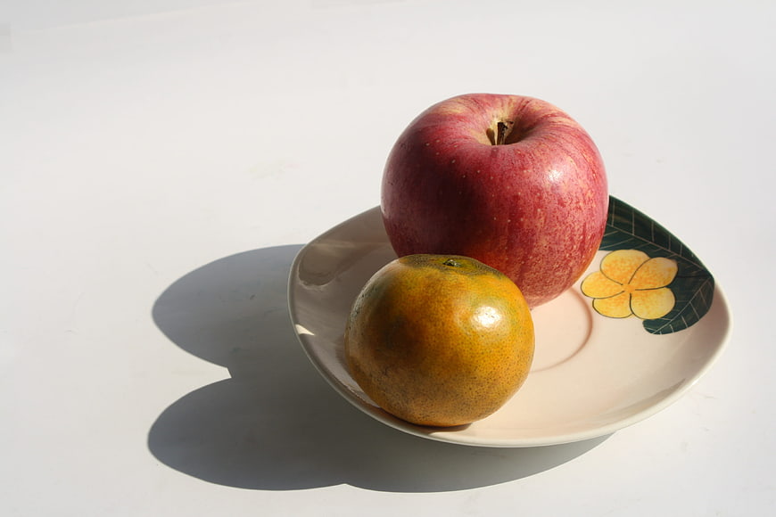 Red Apple and Orange on Decorative Plate
