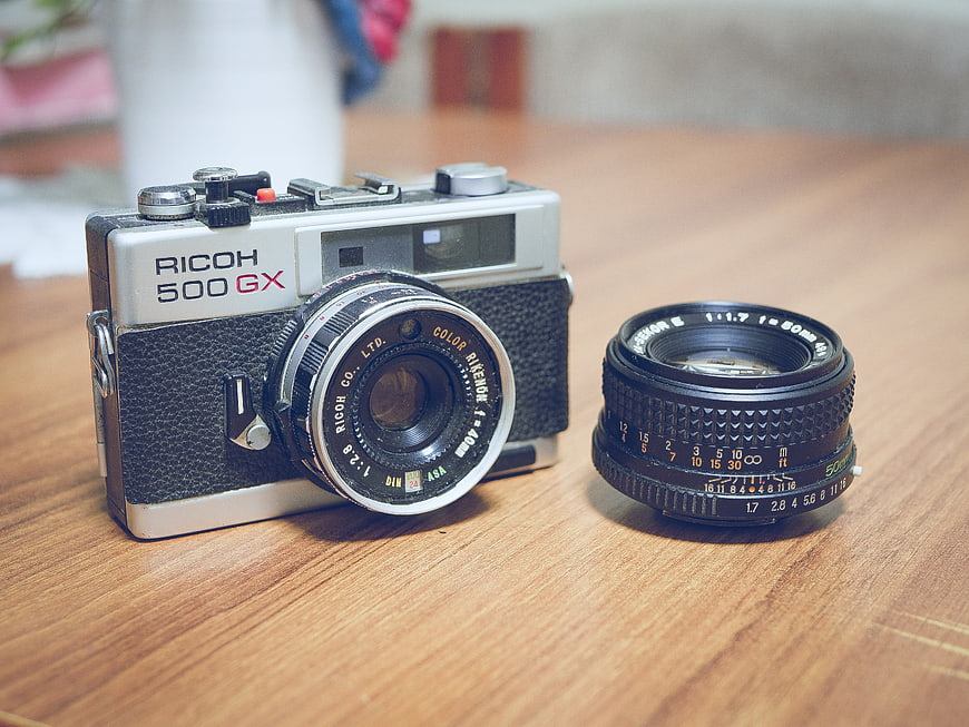 Vintage Ricoh 500 GX Camera and Detachable Lens on Wood