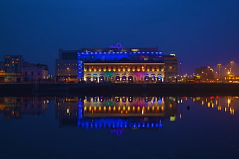 The O2 Arena Dublin illuminated at night with water reflections