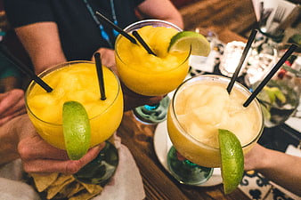 Hands Toasting Yellow and White Frozen Margaritas