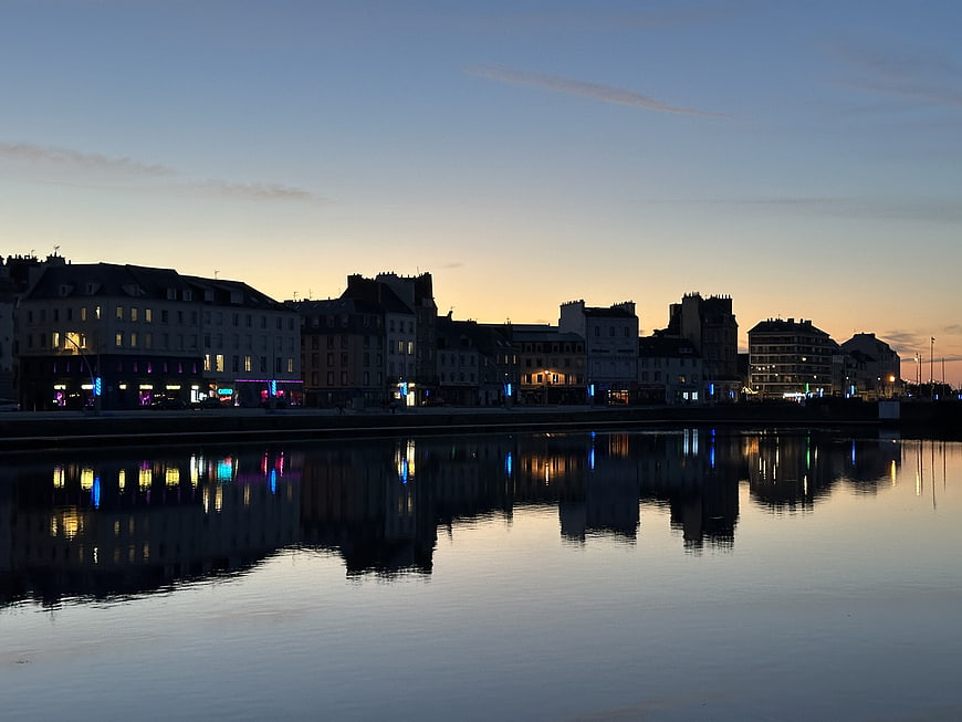 European city skyline at dusk with calm water reflections