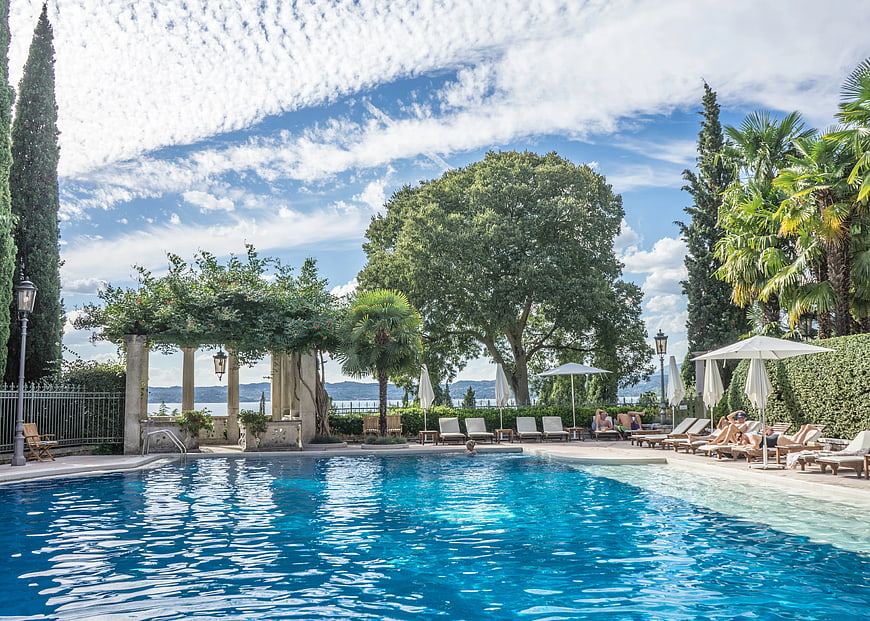Luxury Hotel Pool with Lake View and Lounge Chairs