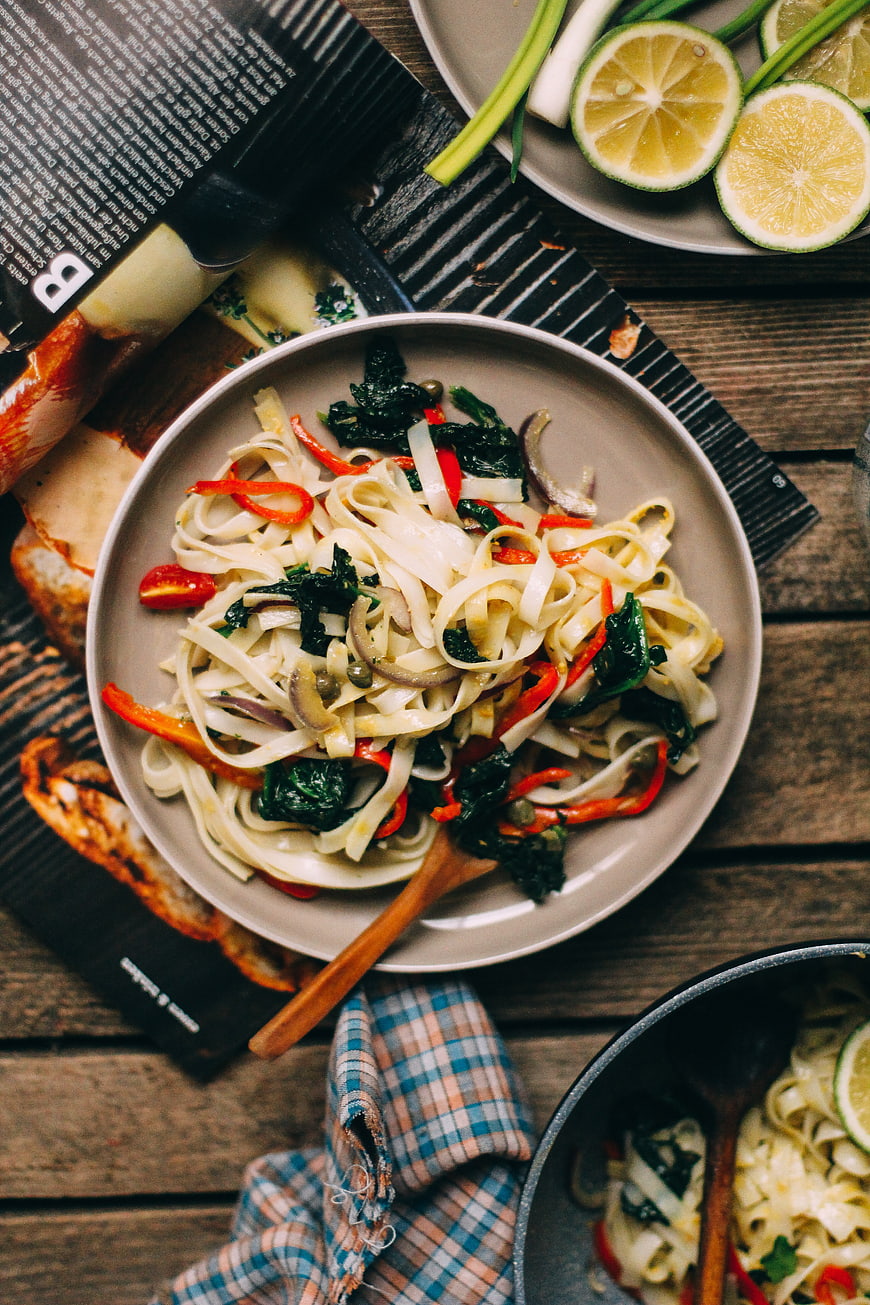 Top view of rice noodles with roasted vegetables and lime