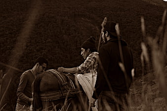 Three Men Preparing Horse in Sepia Toned Rural Landscape