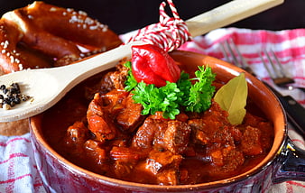 Hearty Beef Goulash in Ceramic Bowl with Pretzel
